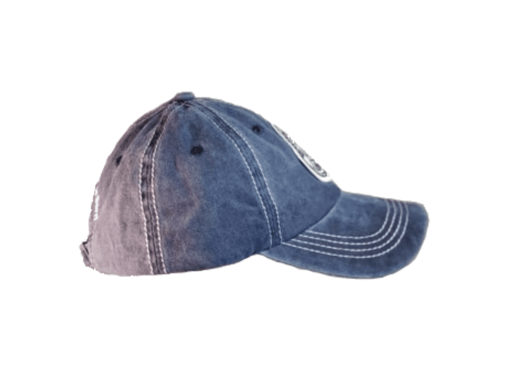A washed blue denim baseball cap with white contrast stitching and a small white embroidered logo on the side, shown against a plain white background.
