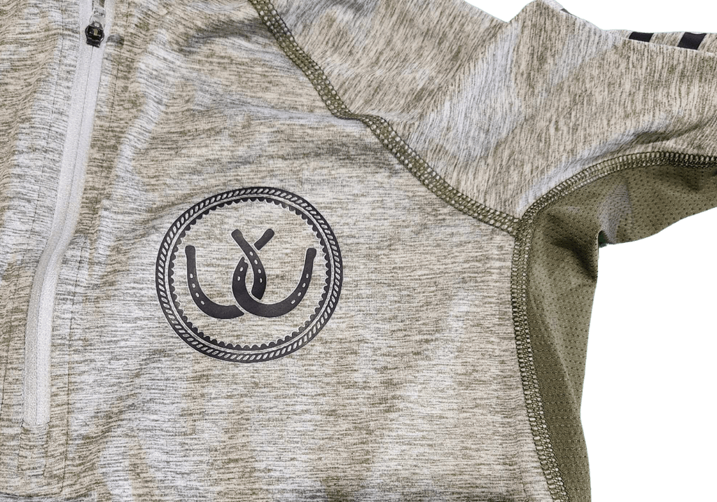 Close-up of a heathered light gray athletic quarter-zip jacket with olive green mesh lining and a black circular horseshoe logo on the chest.