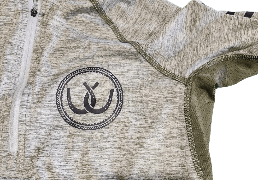 Close-up of a heathered light gray athletic quarter-zip jacket with olive green mesh lining and a black circular horseshoe logo on the chest.