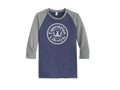 A 3/4 sleeve raglan t-shirt with a heathered navy blue body and heathered gray sleeves, featuring a white circular graphic on the chest that reads 'Equestrian Lifestyle' with a horseshoe symbol.