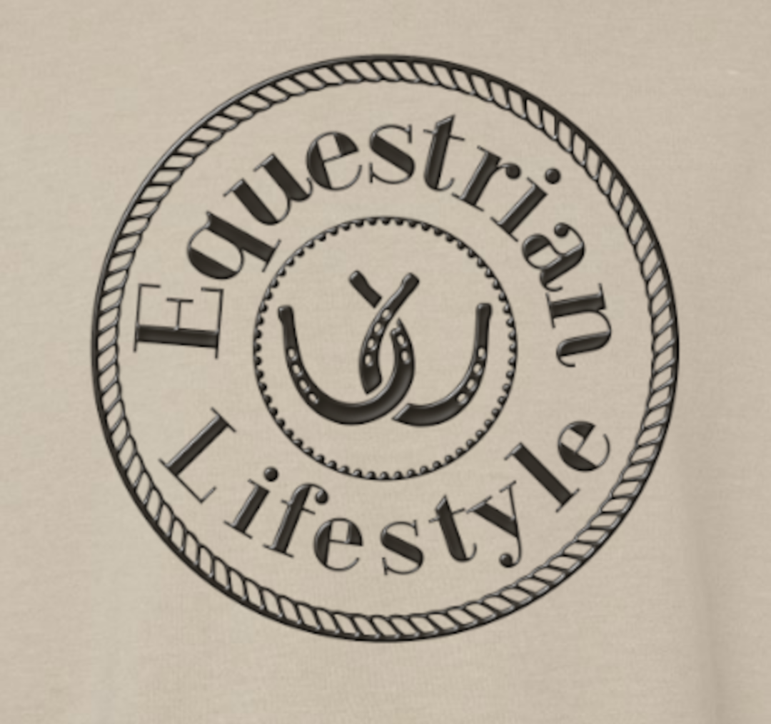 A circular black graphic print on a light beige fabric background, featuring the words 'Equestrian Lifestyle' in an arched serif font around a central horseshoe and rider motif.